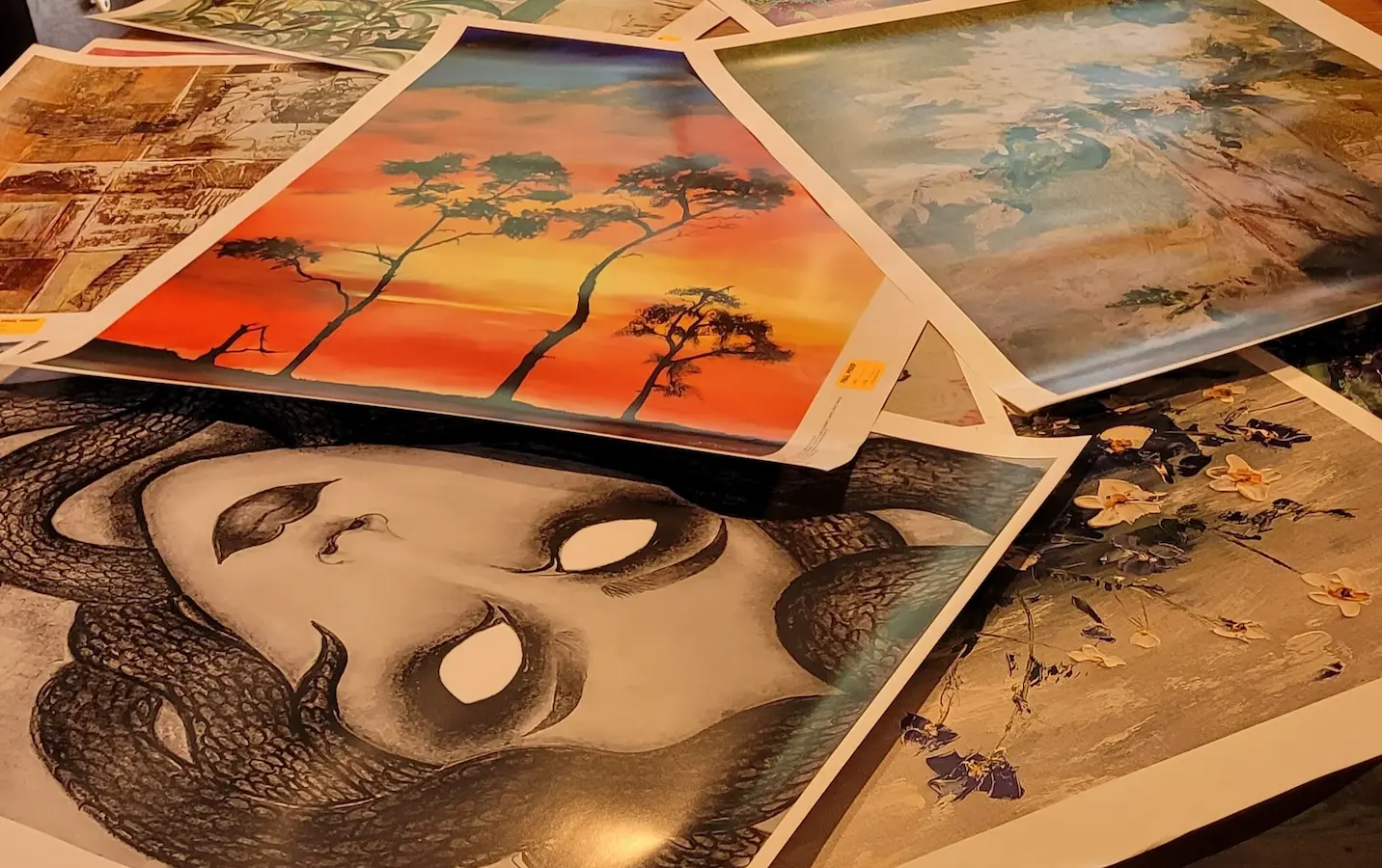Proofs (art prints to be approved or "proofed" before using to make puzzles) scattered across the table.